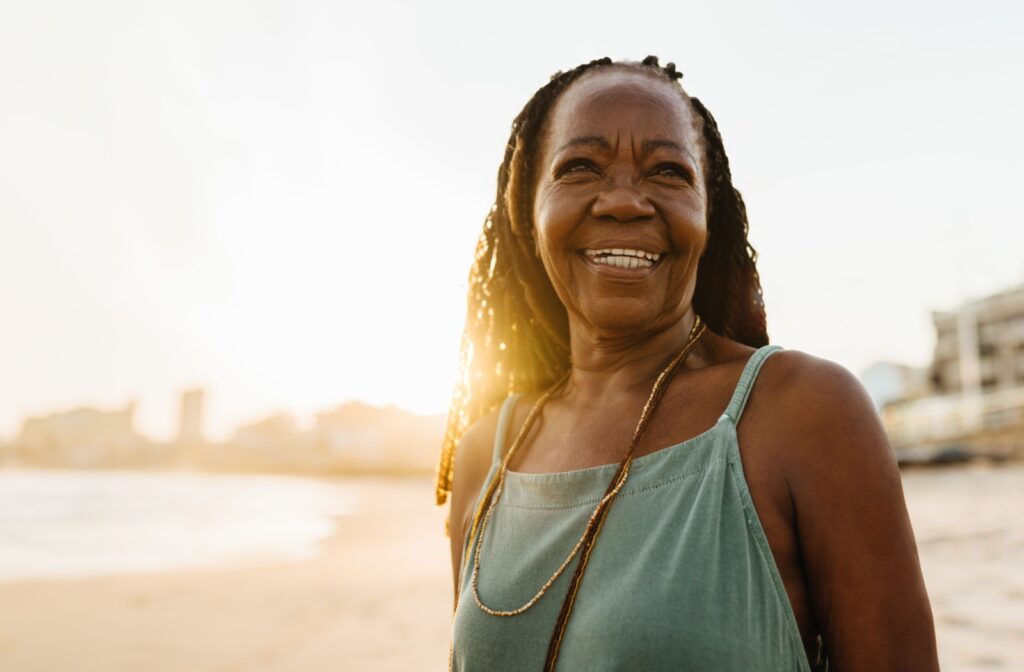 A happy senior enjoys an early morning walk on the beach near their assisted living home