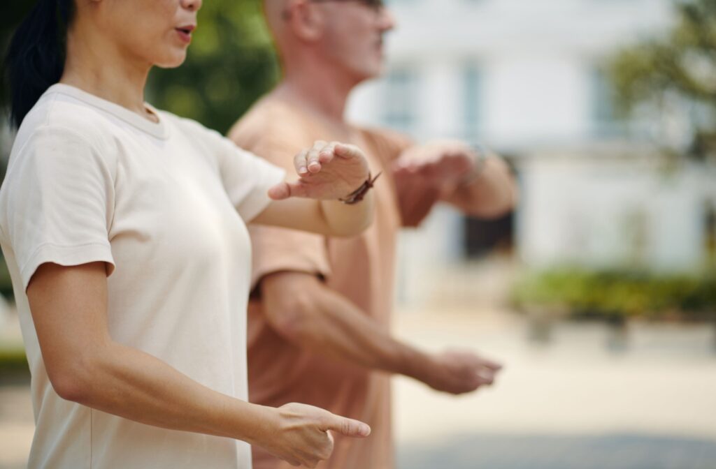 Two seniors practice tai chi together.