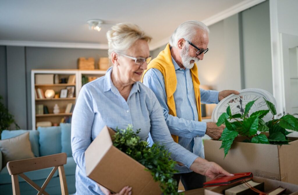 A senior couple packs boxes of faux houseplants as they prepare to move into senior living