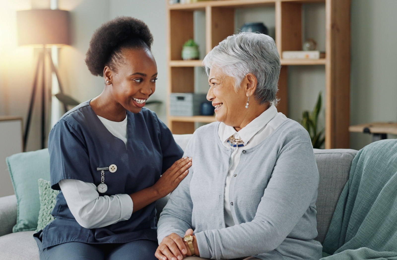 A caregiver smiles at a senior resident